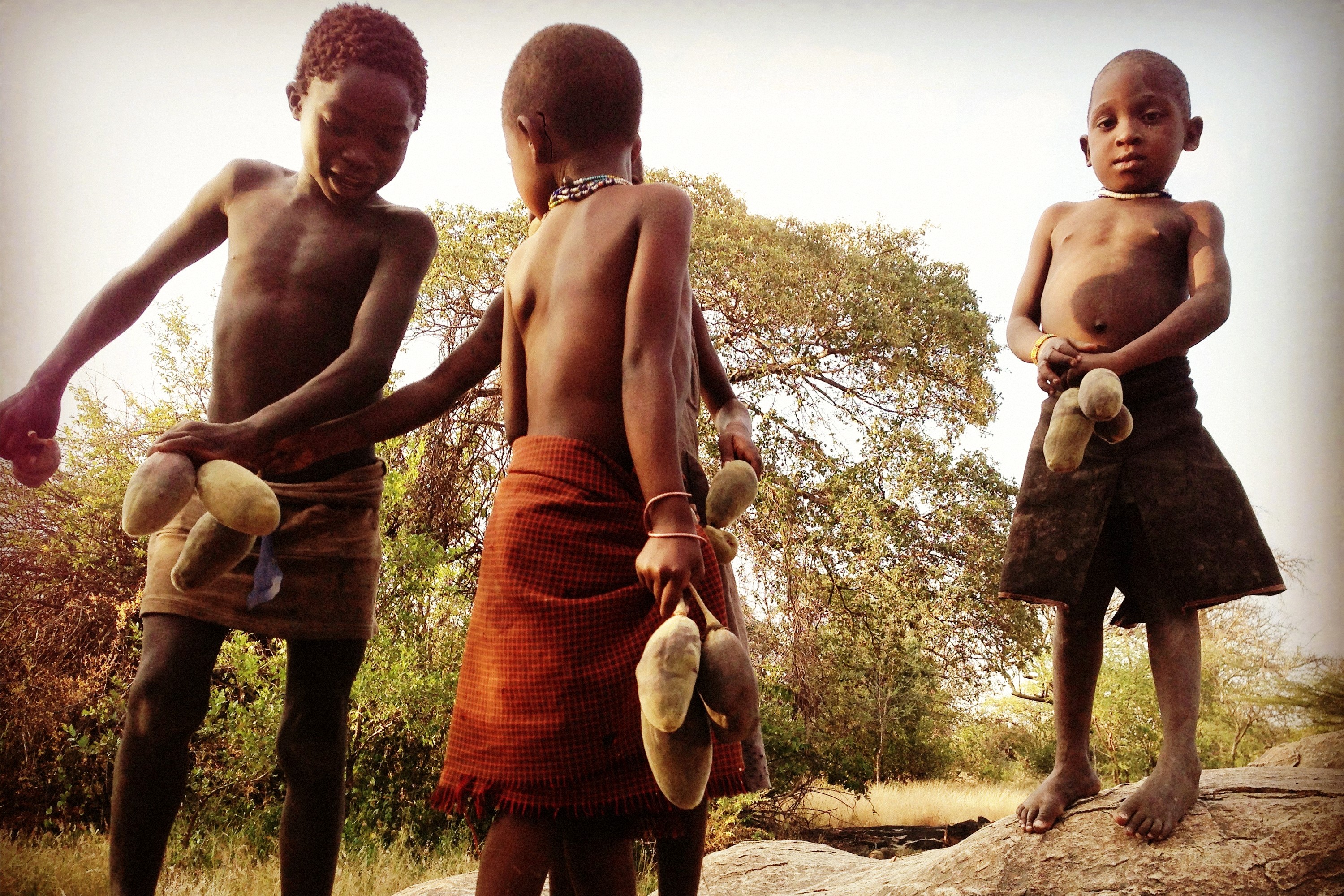 A Hadza child holding a bow near rock shelters in the Yaeda Valley